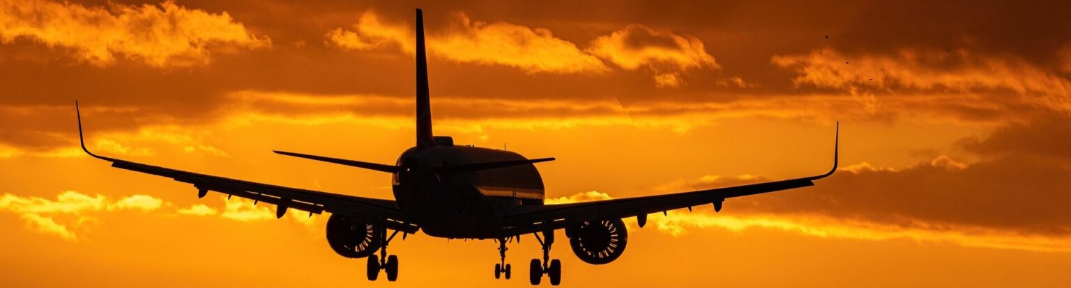 avifares background image for hero section featuring a an airplane in the dusk landing at the airport